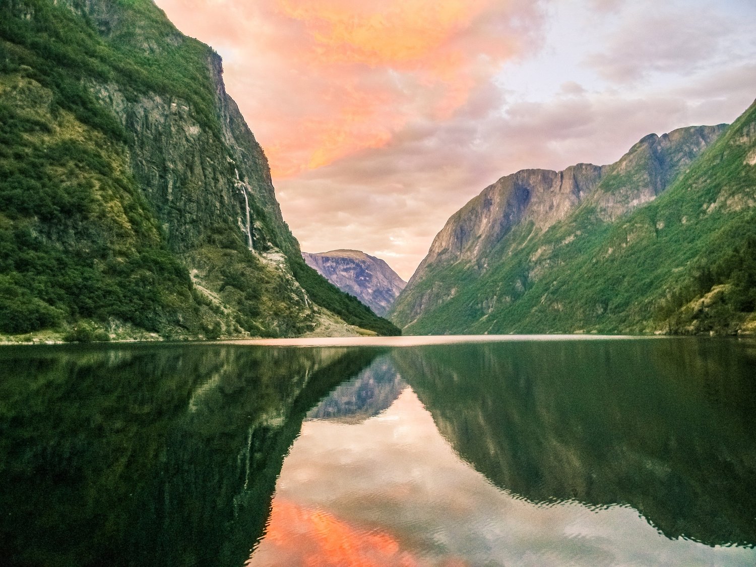 Still black fjord water reflecting the surrounding peaks