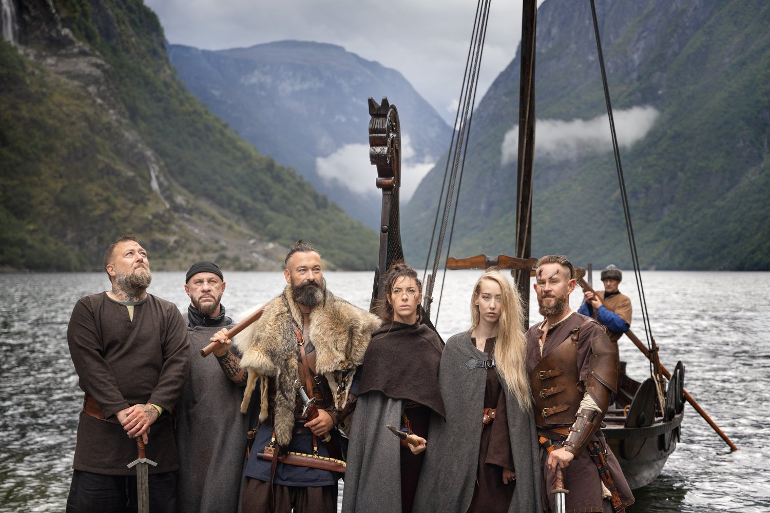 The group standing together with a Viking longship at the water's edge